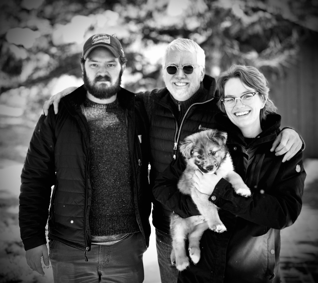 Charles with Max and Sarah standing on either side of him, with Sarah holding a dog