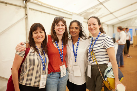 4 Scholars smiling and looking at the camera