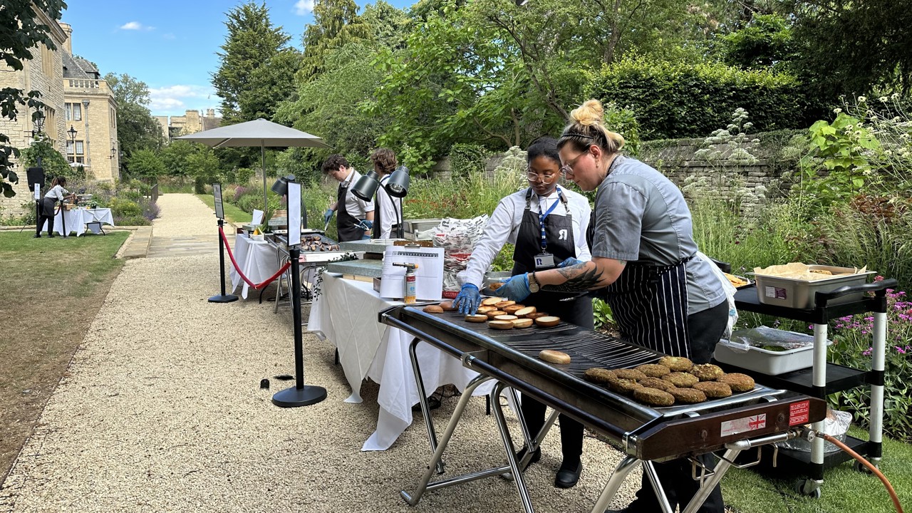 Chefs grilling veggie burgers for a BBQ in the Rhodes House garden.