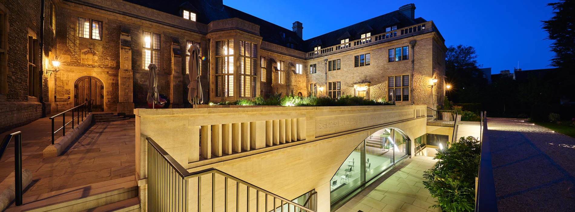 View of the Courtyard at night with lights coming from the windows and steps leading to the Conference Hall below.