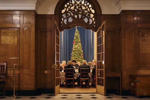 View of McCall MacBain Hall through the door from the vestibule, with Christmas party guests seated.