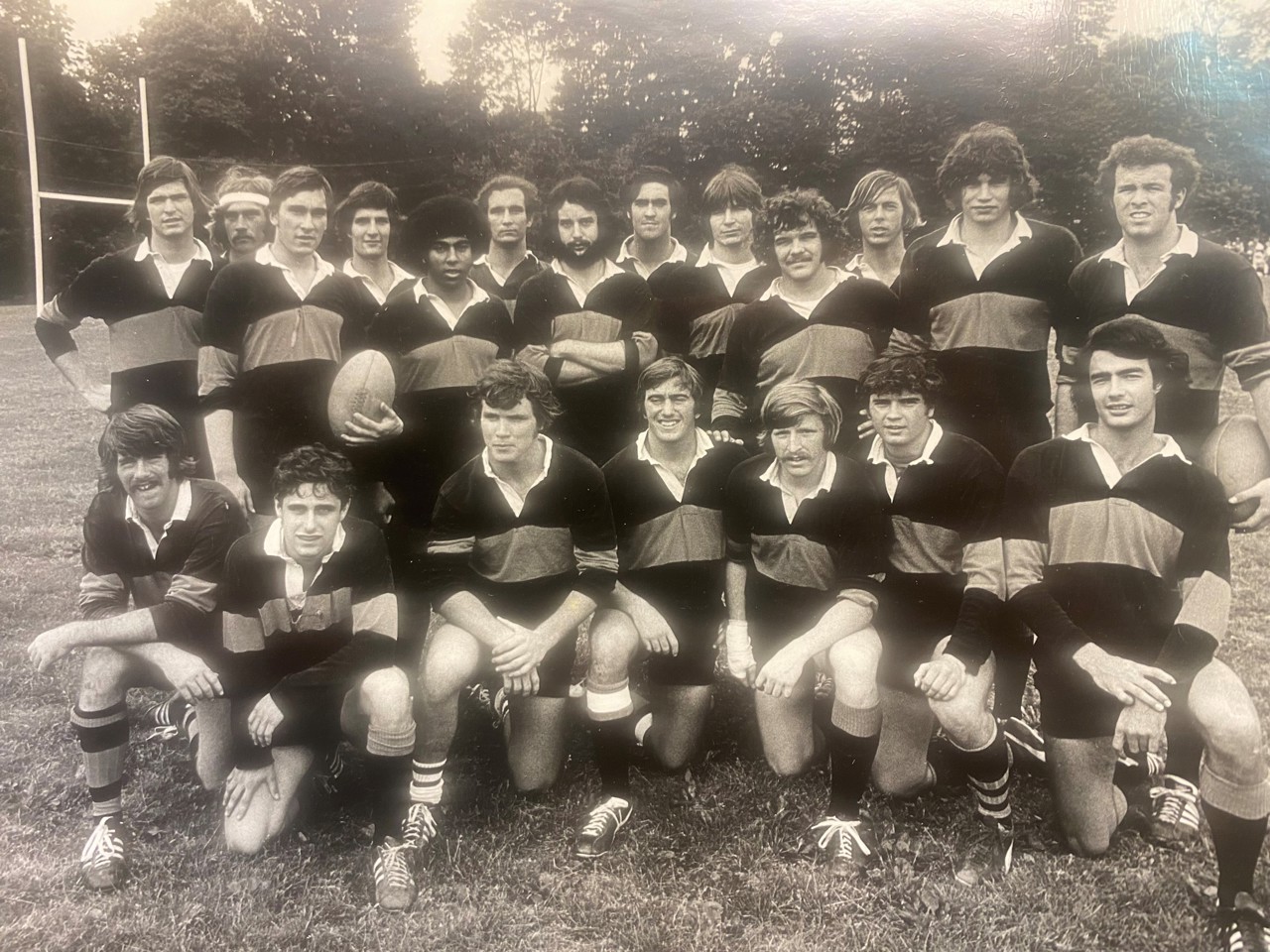 Black and white photo of university rugby team posing in their sports kit.