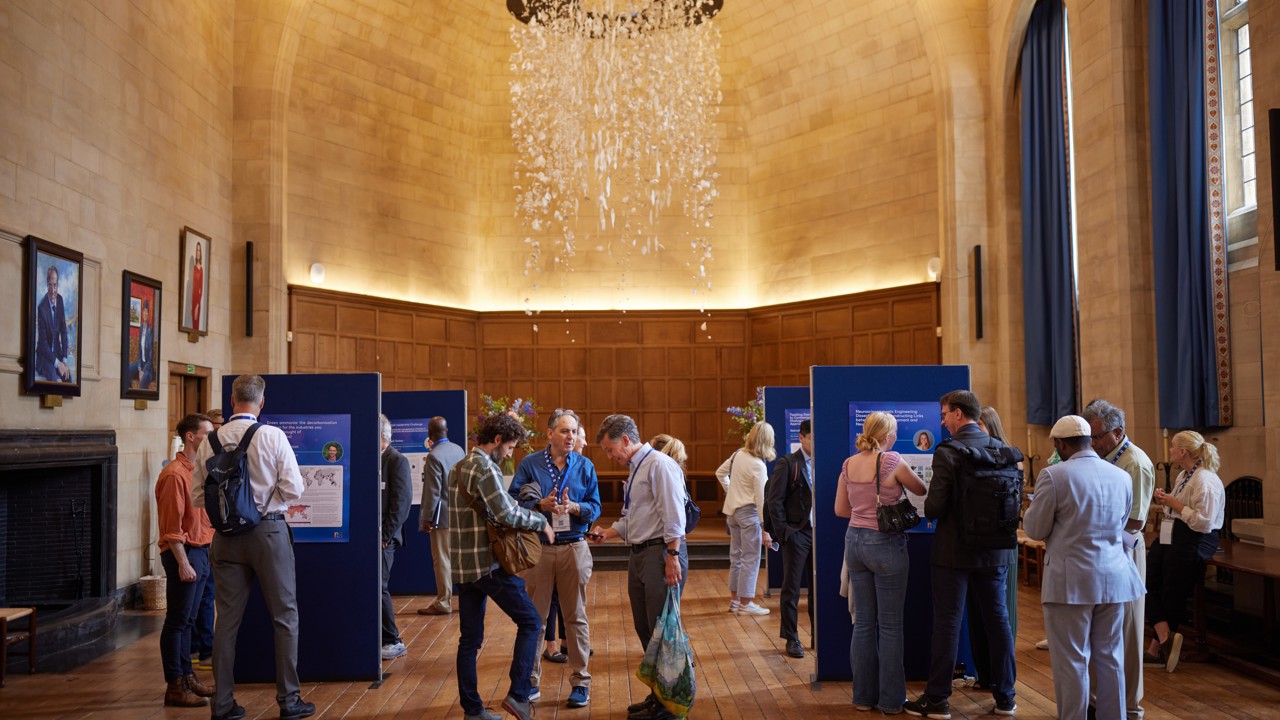 Exhibition boards set up in McCall MacBain Hall with delegates mingling and viewing.