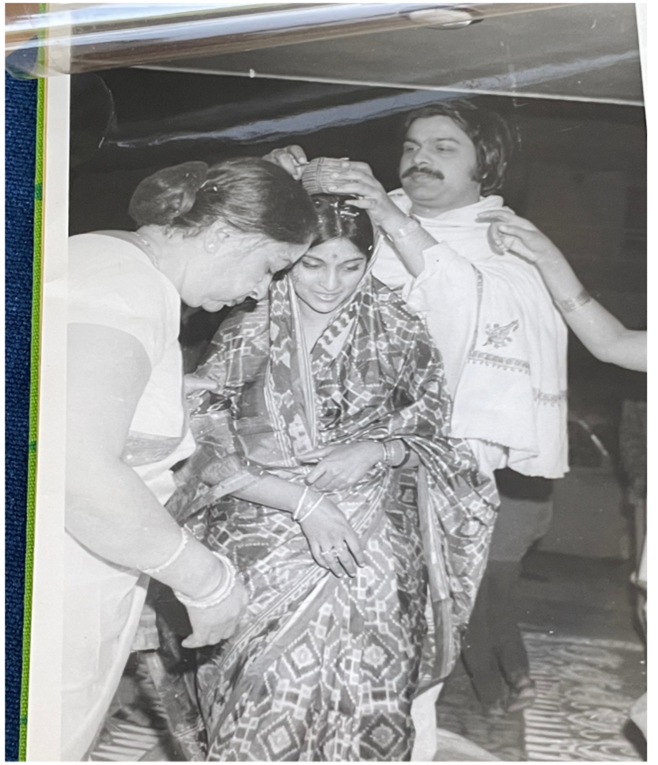 A black-and-white picture showing Jahar and Sunita's wedding, 1972, Delhi. Sunita is being anointed with red “sindoor powder” in hair-parting in a traditional custom.